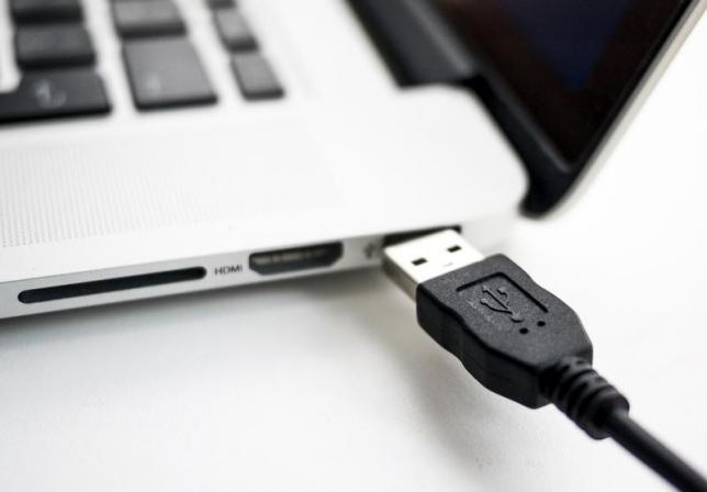 Photo illustration shows USB device being plugged into a laptop computer in Berlin